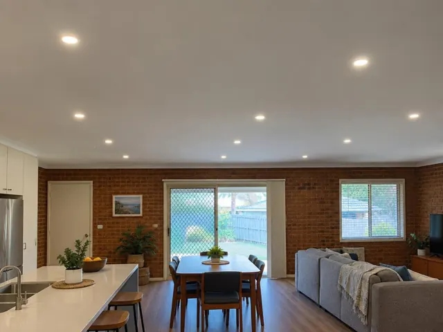 Ceiling with evenly spaced recessed downlights in a brick-walled open-plan home in Umina Beach
